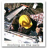 Jim on a ladder repairing the sails